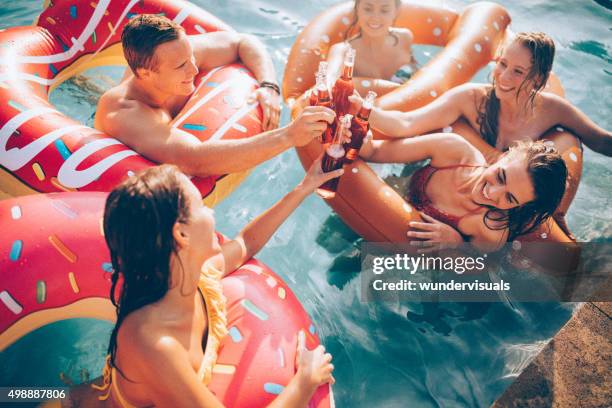 amigos celebrando o verão na piscina com garrafa de bebidas - soda imagens e fotografias de stock