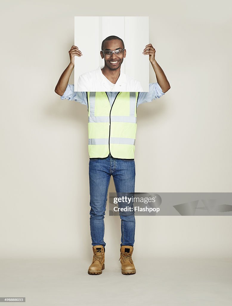 Construction worker holding picture of scientist