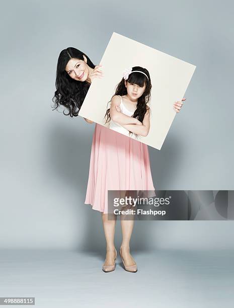woman holding portrait of herself as a child - long hair photos stock-fotos und bilder