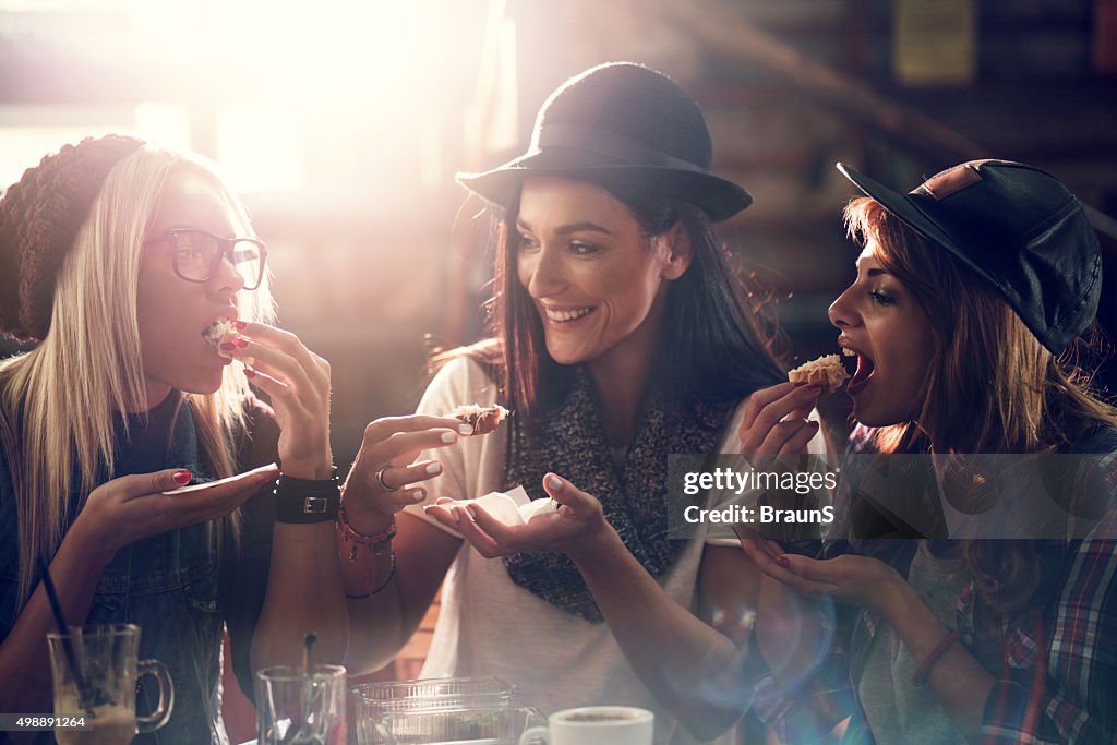 Young female friends having a snack in a cafe.