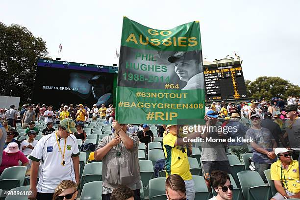 Spectators pay tribute to former cricketer Phillip Hughes at eight minutes past four during day one of the Third Test match between Australia and New...