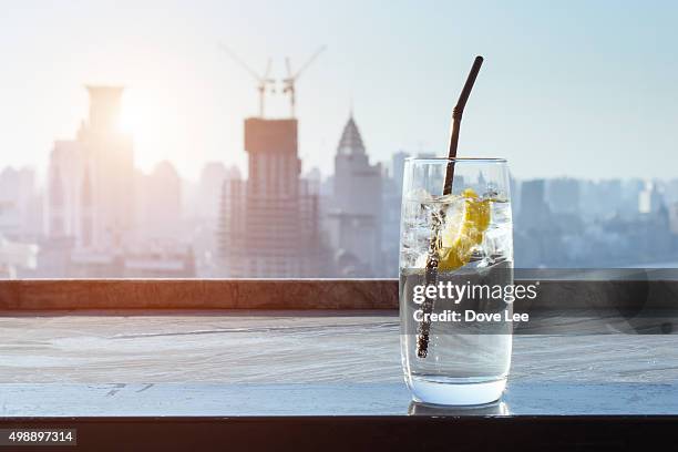 lemon drinks with city background - sparkling water glass stockfoto's en -beelden