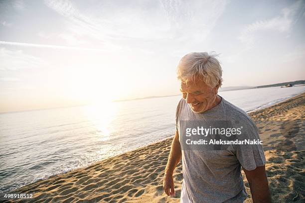 Uomo anziano camminare lungo la spiaggia