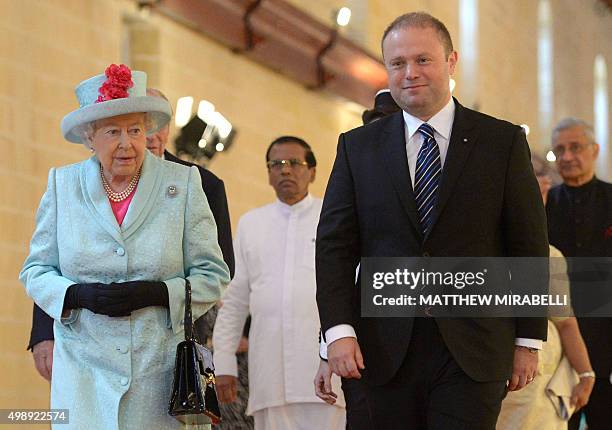 Queen Elizabeth II and Malta's Prime Minister Joseph Muscat arrive to attend the opening ceremony of the Commonwealth Heads of Government Meeting at...