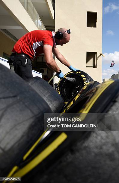 Manor Marussia F1 Team crew member washes tyres during the first practice session at the Yas Marina circuit in Abu Dhabi on November 27, 2015 ahead...