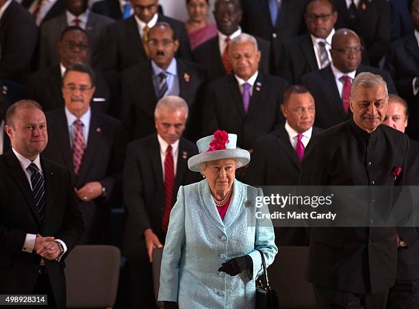 Queen Elizabeth II leaves with Commonwealth Secretary General Kamalesh Sharma, following the family photograph at the CHOGM opening ceremony at the...