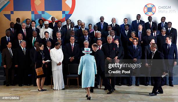 Queen Elizabeth II joins Commonwealth Heads of State as she arrives for a group photograph at CHOGM opening ceremony at the Mediterranean Conference...