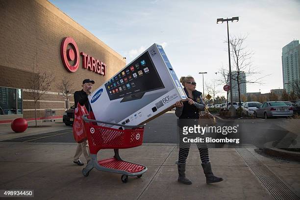 Customers push a Samsung Electronics Co. Television to their car outside of a Target Corp. Store in Jersey City, New Jersey, U.S., on Friday, Nov....