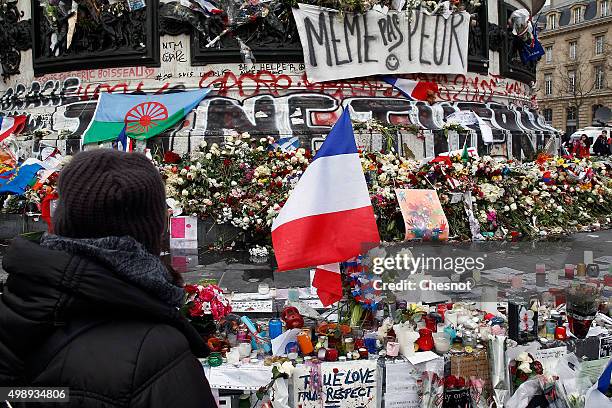 Woman looks at a French flag at "Place de la Republique" on November 27, 2015 in Paris, France. French President Francois Hollande called on all...