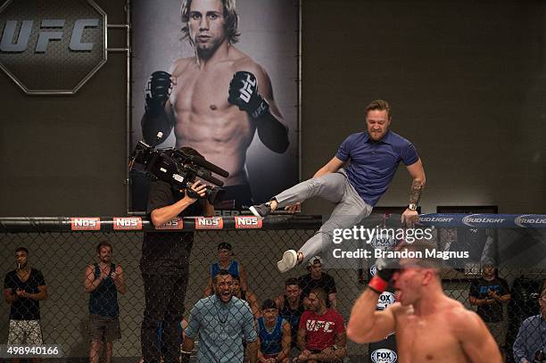 Head coach Conor McGregor jumps into the Octagon after Artem Lobov knocks out Chris Gruetzemacher during the filming of The Ultimate Fighter: Team...