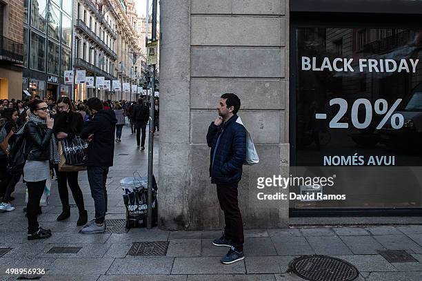 Shopper stands next a 'Black Friday' discount banner in Portal Del l'Angel street on November 27, 2015 in Barcelona, Spain. Originating in the USA as...