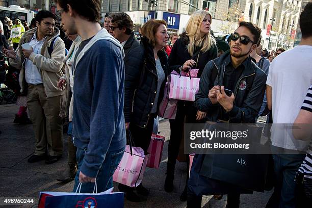 Pedestrians carry shopping bags on Black Friday through Herald Square in New York, U.S., on Friday, Nov. 27, 2015. In 2011, several big U.S....