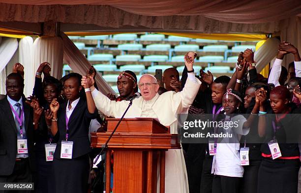 Pope Francis joins hands with members of the congregation at the Kasarani Sport Stadium in Nairobi on November 27, 2015. Pope Francis is in an...