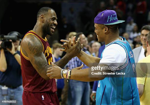 LeBron James of the Cleveland Cavaliers talks to Cam Newton, quarterback of the Carolina Panthers after the Cavaliers defeated the Hornets 95-90 at...