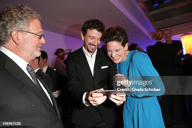 Oliver Berben shows his baby son on the smart phone to Bibiana Beglau during the ARD advent dinner hosted by the program director of the tv station...