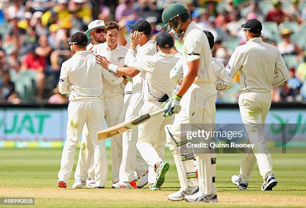 Mitchell Santner of New Zealand is congratulated by team mates after taking the wicket of Josh Hazlewood of Australia during day two of the Third...