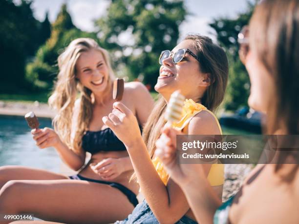 teen girl friends laughing with ice creams next to pool - young girls swimming pool stock pictures, royalty-free photos & images