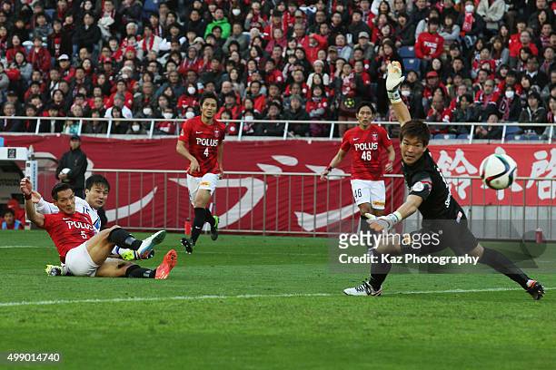 Yasuyuki Konno of Gamba Osaka scores his team's first goal past Shusaku Nishikawa of Urawa Red Diamonds during the J.League 2015 Championship semi...