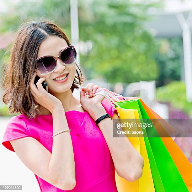 young woman shopping and talking on phone - square one mall stock pictures, royalty-free photos & images