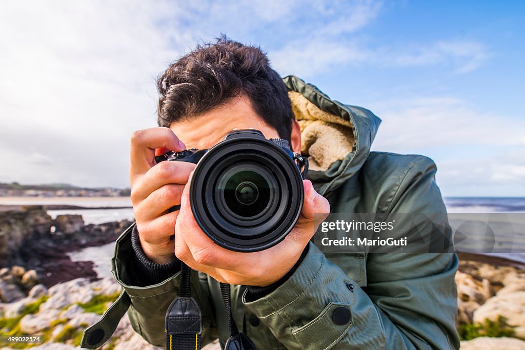 Young man using DSLR camera