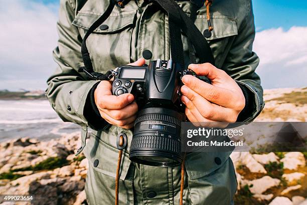 jeune homme tenant un appareil photo - appareil photo numérique photos et images de collection
