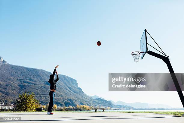 jogador de basquete atirando a bola em arco - arremessar imagens e fotografias de stock