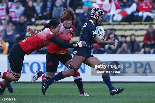 Makiko Tomita of Japan is tackled by Guan Qishi of China during the World Sevens Asia Olympic Qualification match between Japan and China at Prince...