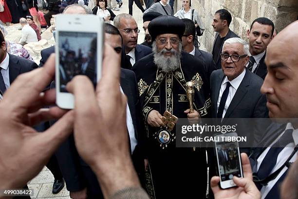 Members of the Coptic community pose for a picture with Egyptian Coptic Pope Tawadros II after the funeral of Archbishop Anba Abraham, the head of...