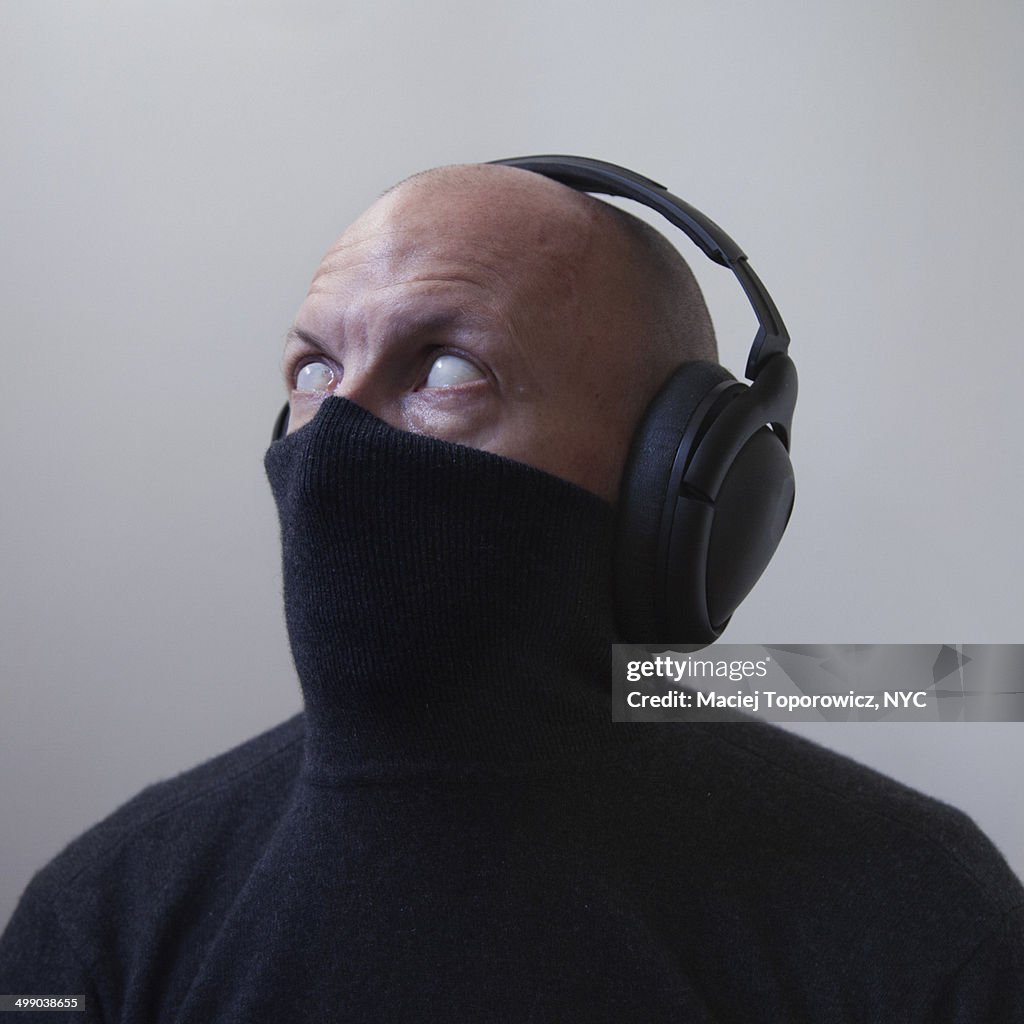 Portrait of blind/spooky masked man in headphones