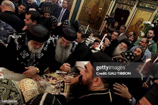 Coptic clergy pray over the open cascade of Archbishop Anba Abraham, the head of the Coptic Church in the Holy Land during his funeral procession on...