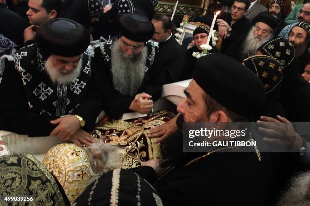 Coptic clergy pray over the open cascade of Archbishop Anba Abraham, the head of the Coptic Church in the Holy Land during his funeral procession on...