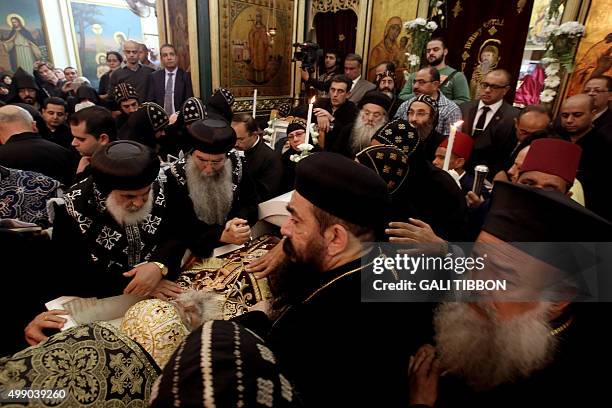 Coptic clergy pray over the open cascade of Archbishop Anba Abraham, the head of the Coptic Church in the Holy Land during his funeral procession on...