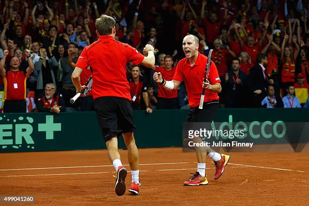 Steve Darcis and David Goffin of Belgium celebrate winning the second set against Jamie Murray and Andy Murray of Great Britain in the doubles during...