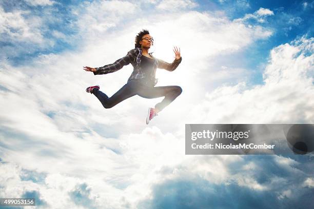 young urban american black female jumping across the sky - afro amerikaanse cultuur stockfoto's en -beelden