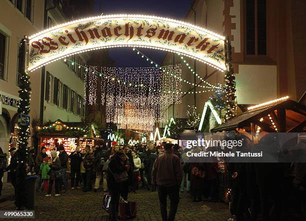 Visitors walk past the stalls at the annual christmas market on November 28, 2015 in Freiburg in Breisgau, Germany. Christmas markets are opening...