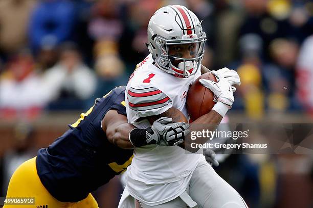 Terry Richardson of the Michigan Wolverines tackles Braxton Miller of the Ohio State Buckeyes during the second quarter at Michigan Stadium on...