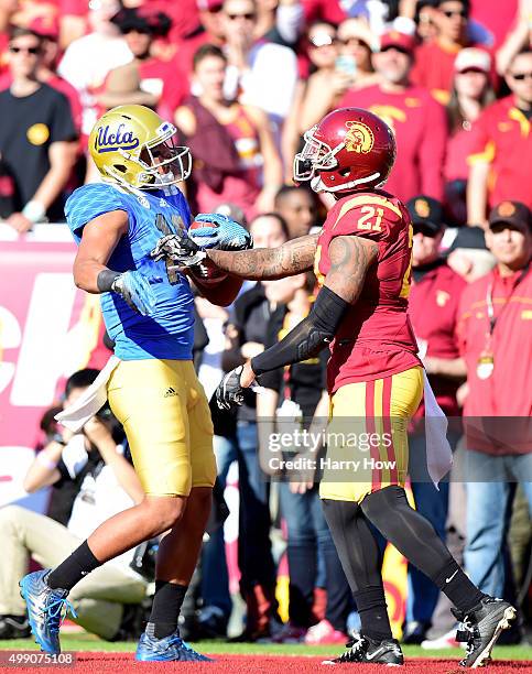 Thomas Duarte of the UCLA Bruins celebrates his touchdown in front of Su'a Cravens of the USC Trojans to take a 14-10 lead during the second quarter...