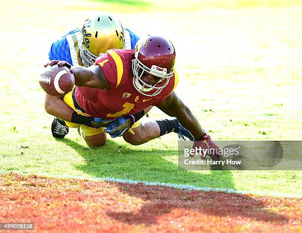 Darreus Rogers of the USC Trojans reaches for the end zone as he is tackled by Nate Meadors of the UCLA Bruins to score a touchdown to take a 33-21...