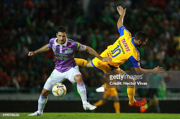 Andre Pierre Gignac of Tigres struggles for the ball with Javier Munoz of Chiapas during the quarterfinals second leg match between Chiapas and...
