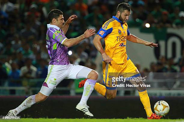 Andre Pierre Gignac of Tigres shoots the ball over the mark of Javier Munoz of Chiapas during the quarterfinals second leg match between Chiapas and...