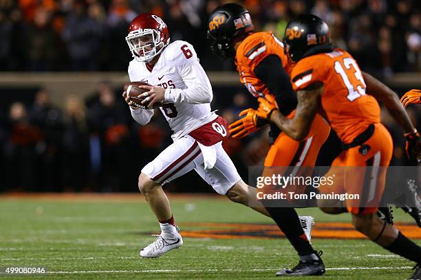 Quarterback Baker Mayfield of the Oklahoma Sooners scrambles against safety Jordan Sterns of the Oklahoma State Cowboys in the first quarter at Boone...
