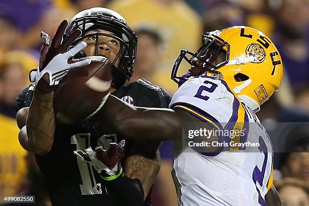 Josh Reynolds of the Texas A&M Aggies catches a pass under pressure from Kevin Toliver II of the LSU Tigers at Tiger Stadium on November 28, 2015 in...
