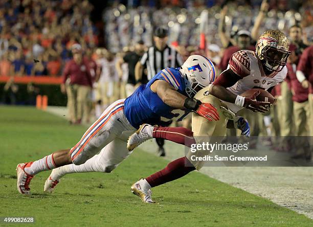 Antonio Morrison of the Florida Gators tackles Kermit Whitfield of the Florida State Seminoles during the game at Ben Hill Griffin Stadium on...