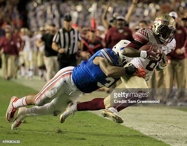 Antonio Morrison of the Florida Gators tackles Kermit Whitfield of the Florida State Seminoles during the game at Ben Hill Griffin Stadium on...
