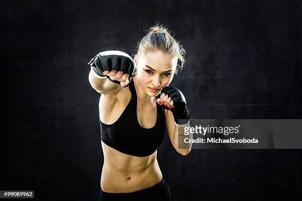 frau kämpfer punching nahaufnahme - mixed martial arts stock-fotos und bilder