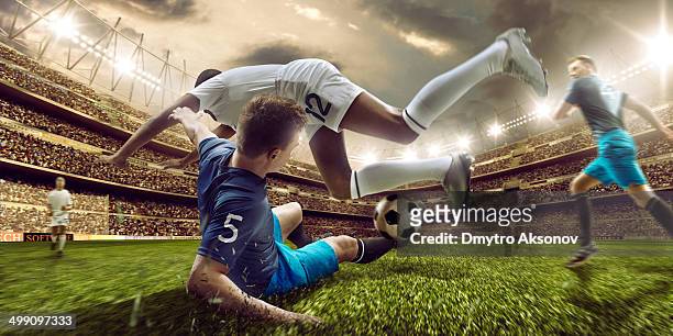 soccer stadium and soccer players in action - tackling stock pictures, royalty-free photos & images