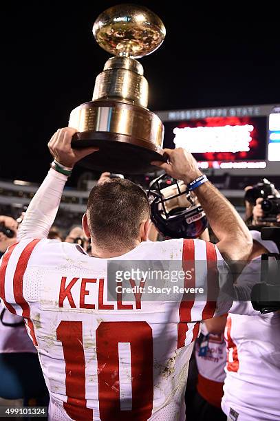 Chad Kelly of the Mississippi Rebels carries the Golden Egg trophy following a victory over the Mississippi State Bulldogs at Davis Wade Stadium on...