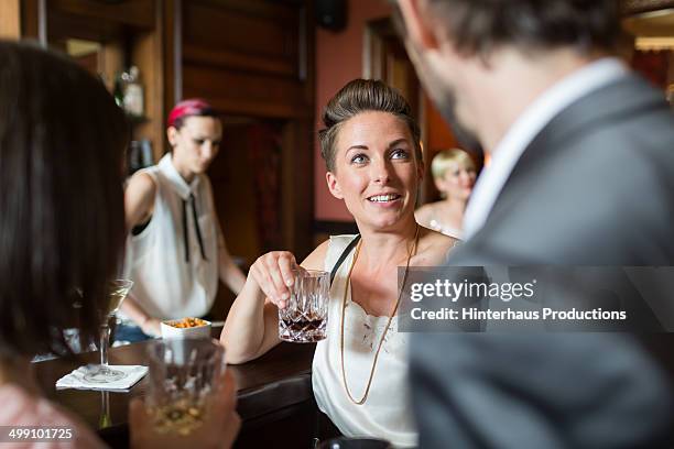 mature adults chatting in a bar - whisky bar stock-fotos und bilder