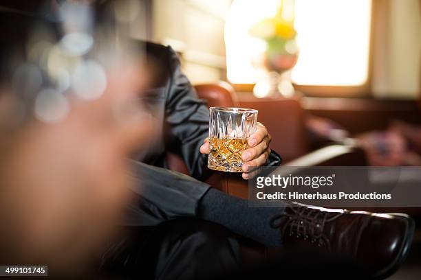 businessman holding whiskey glass - hard liquor fotografías e imágenes de stock