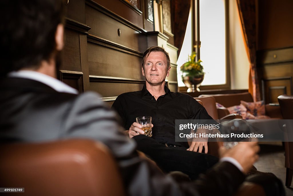 Two mature businessman having whiskey in a bar